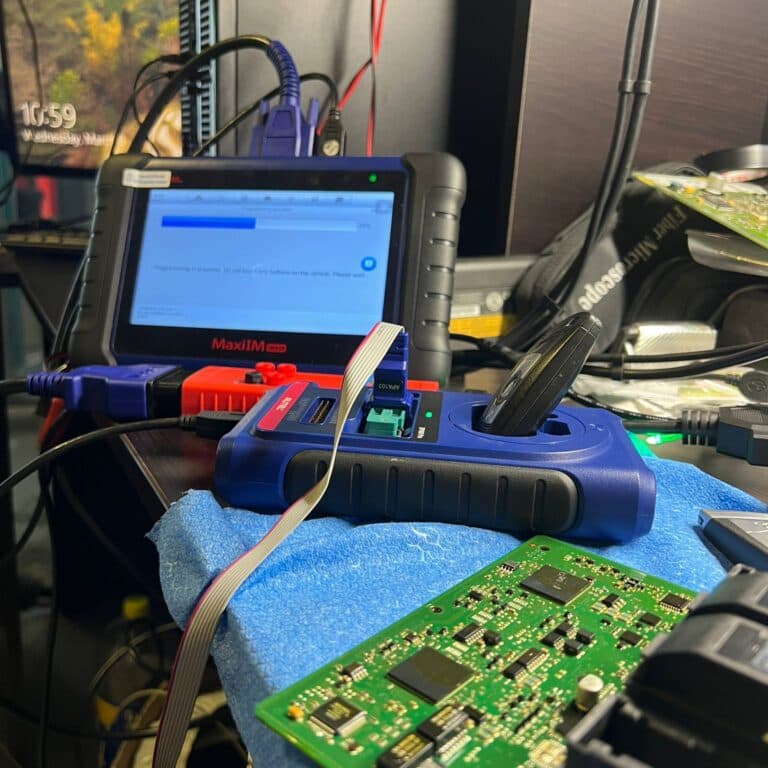 Programator Autel MaxiIM IM608 cu modulul XP400, o cheie Mercedes introdusă în lăcaș și o placă de imobilizator conectată alături