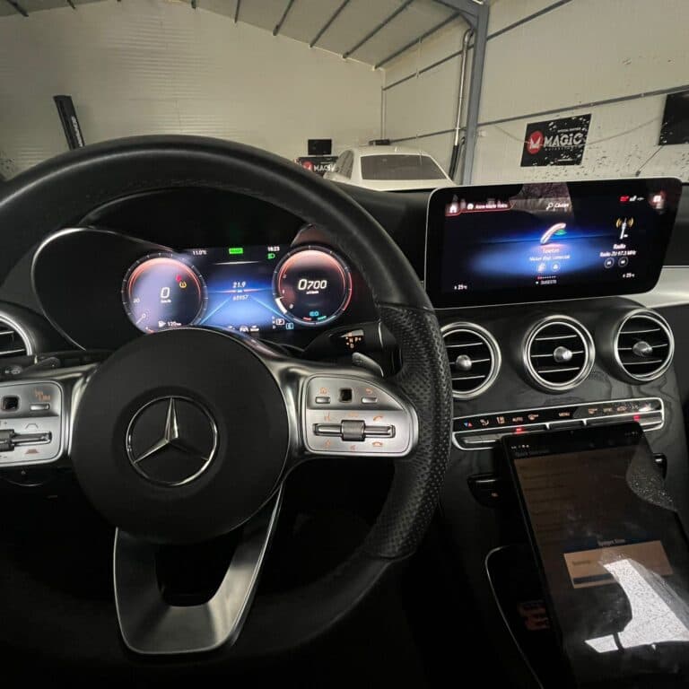 Bordul unui Mercedes C-Class cu ceasuri digitale și ecran MBUX active, în timpul unei sesiuni de codare