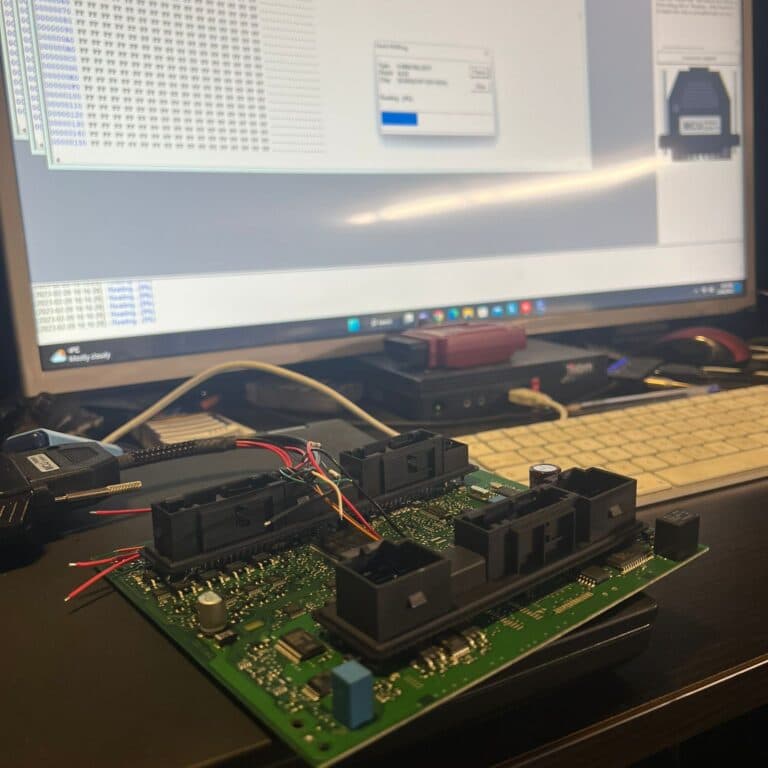 Placă de calculator auto cu conectori demontați, în timpul citirii memoriei afișate în hexazecimal pe monitor