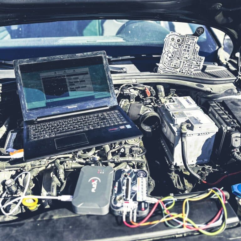 Compartiment motor deschis, cu laptop de diagnoză și mecatronic de cutie automată alături